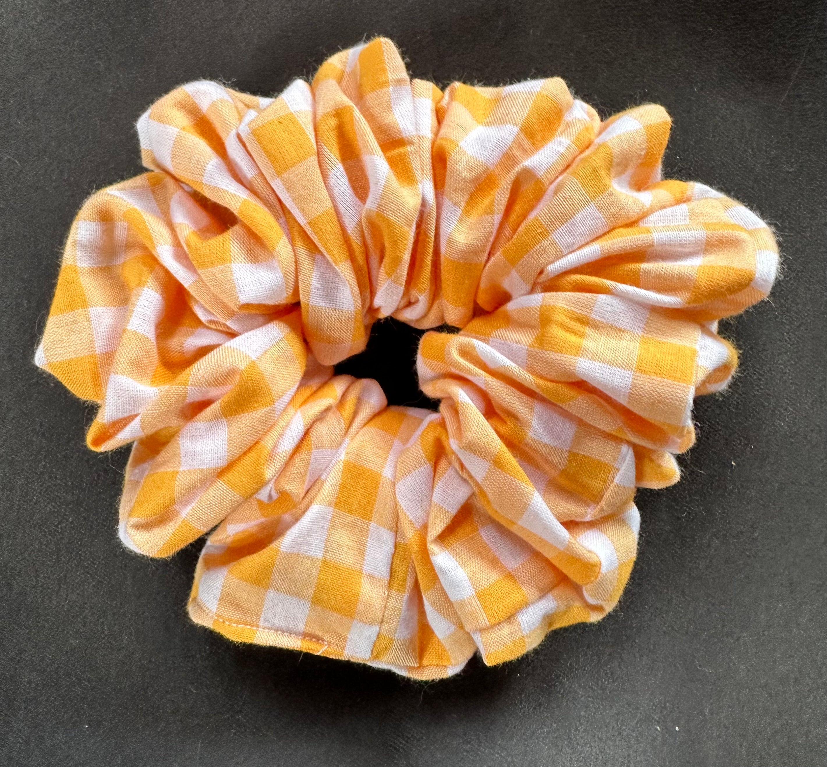 Yellow and white checkered scrunchie on a dark background