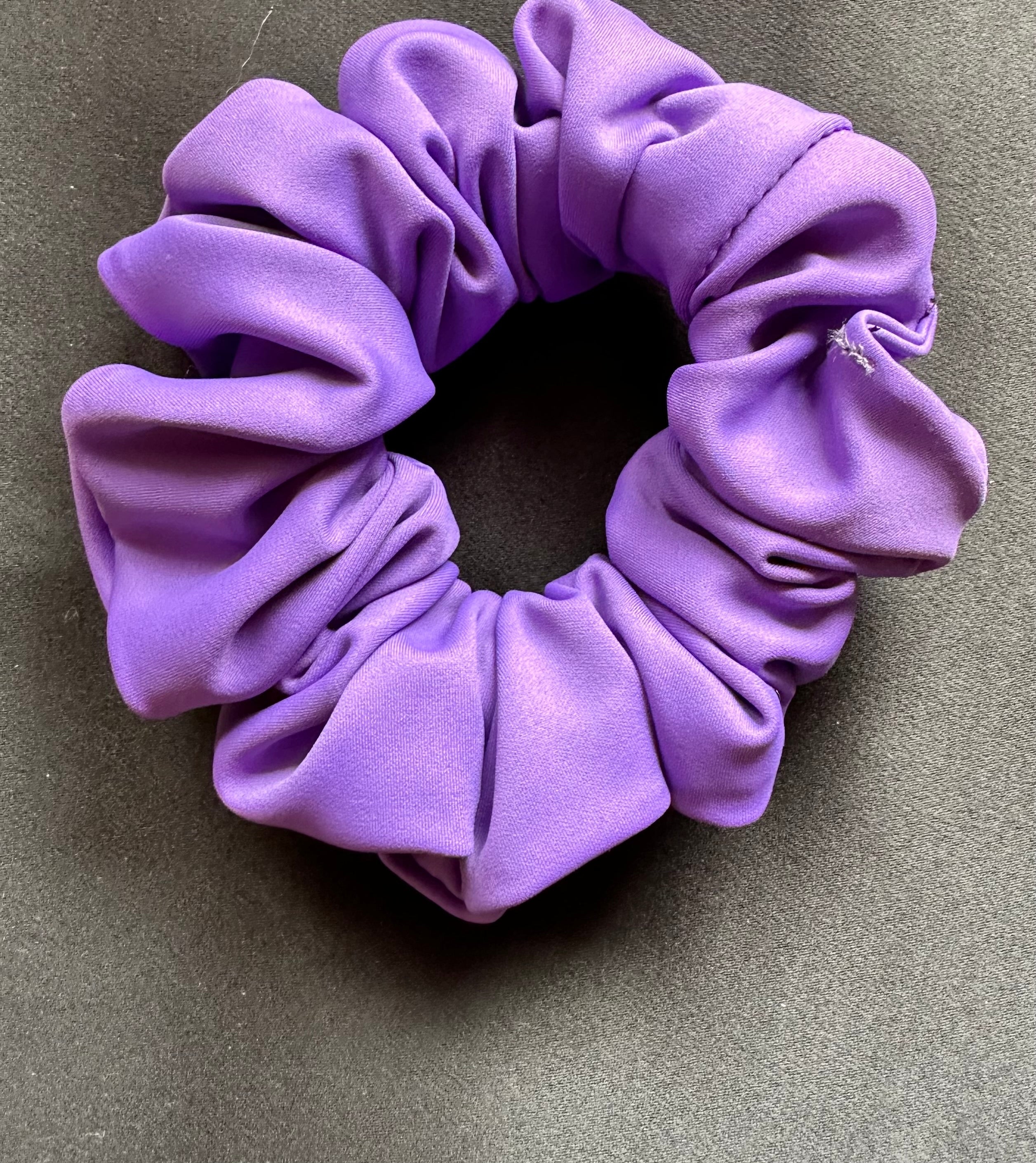 Purple scrunchie on a gray background